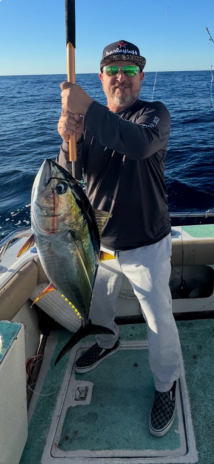 Angler displaying a tuna aboard the boat