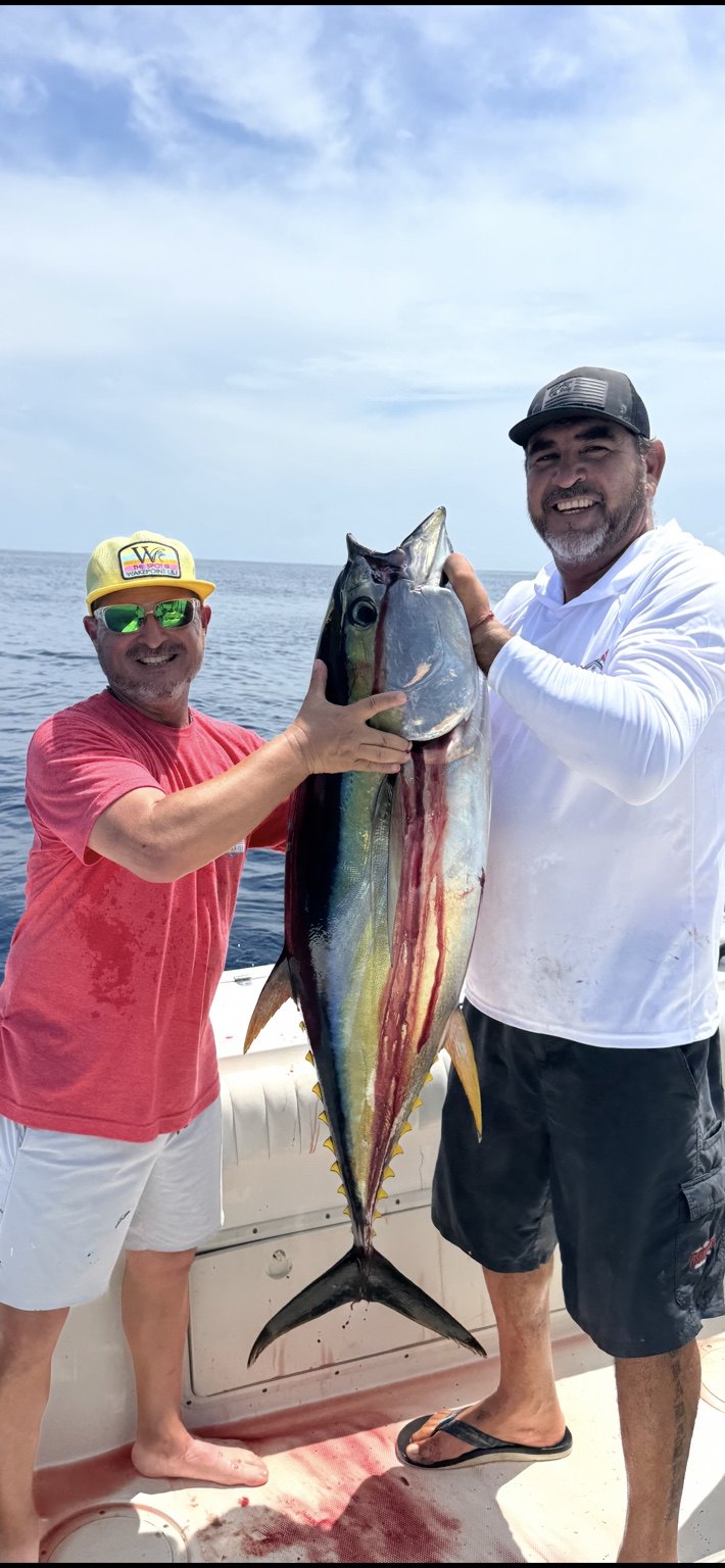 Two anglers displaying a tuna catch