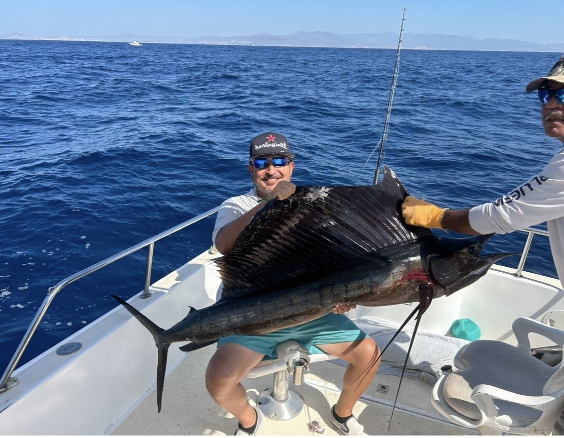 Angler with a sailfish at sea